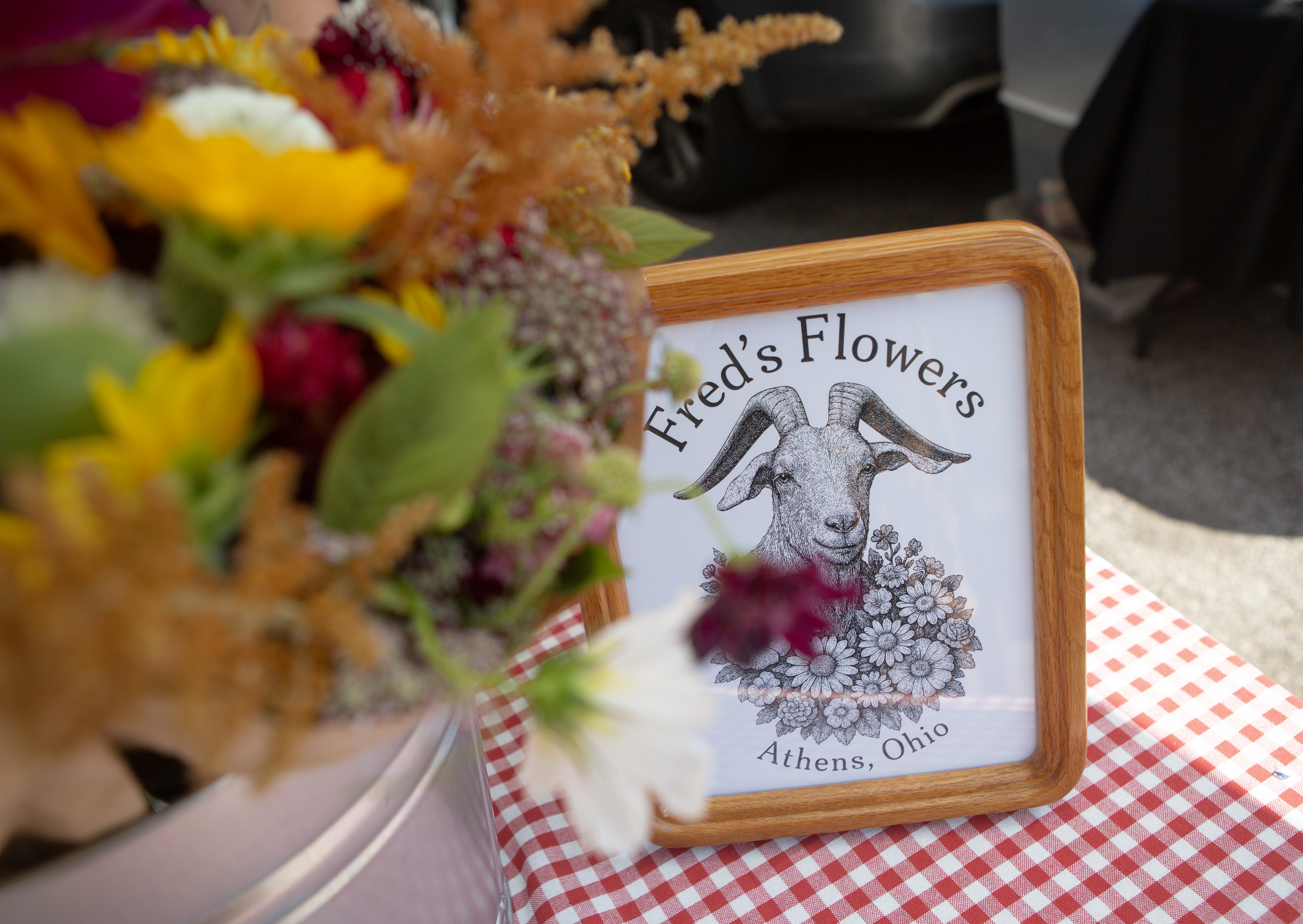Fred's Flowers market sign with a fresh bouquet